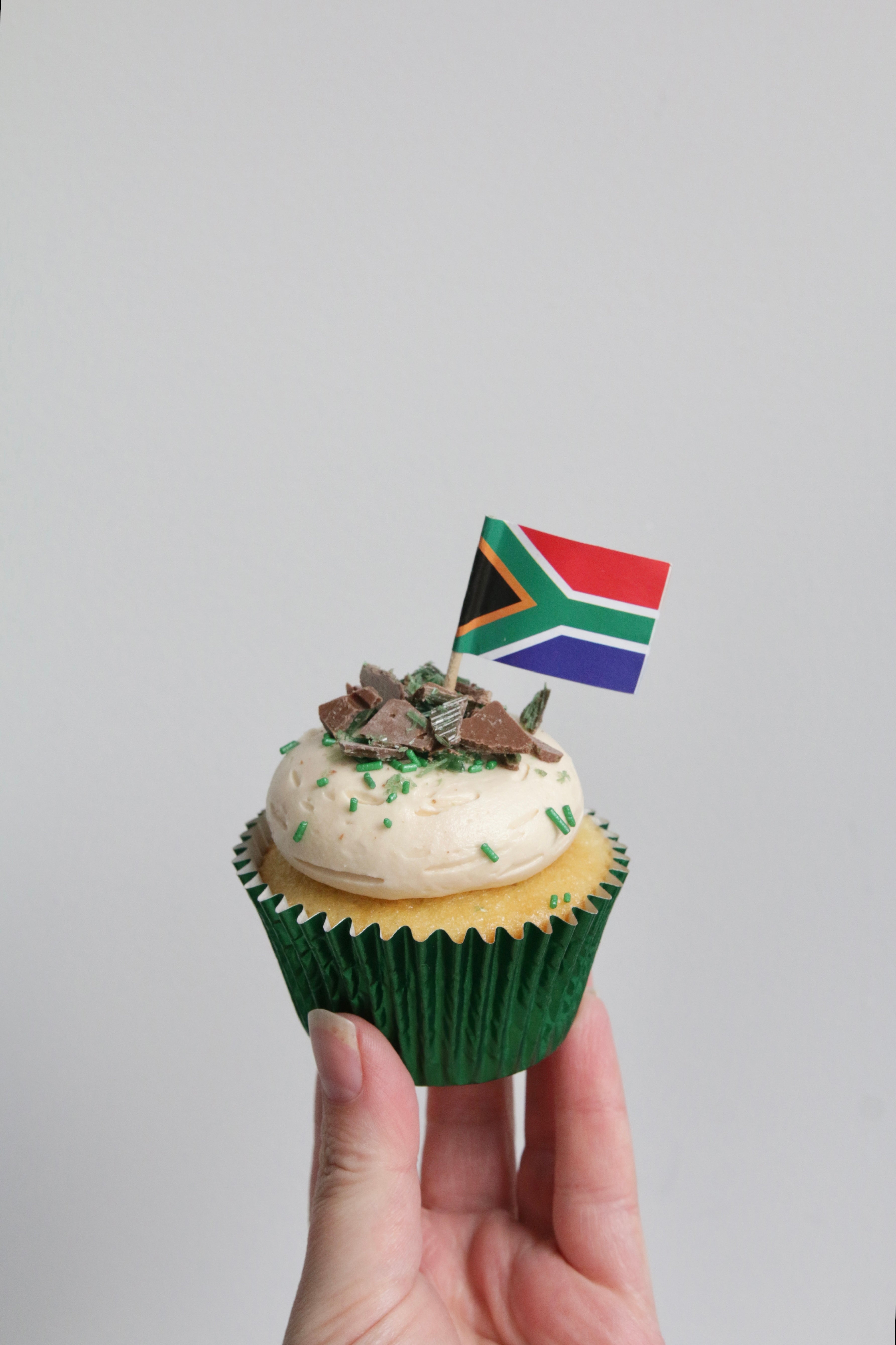 Holding a Single Peppermint Crisp Cupcake with South African Flag