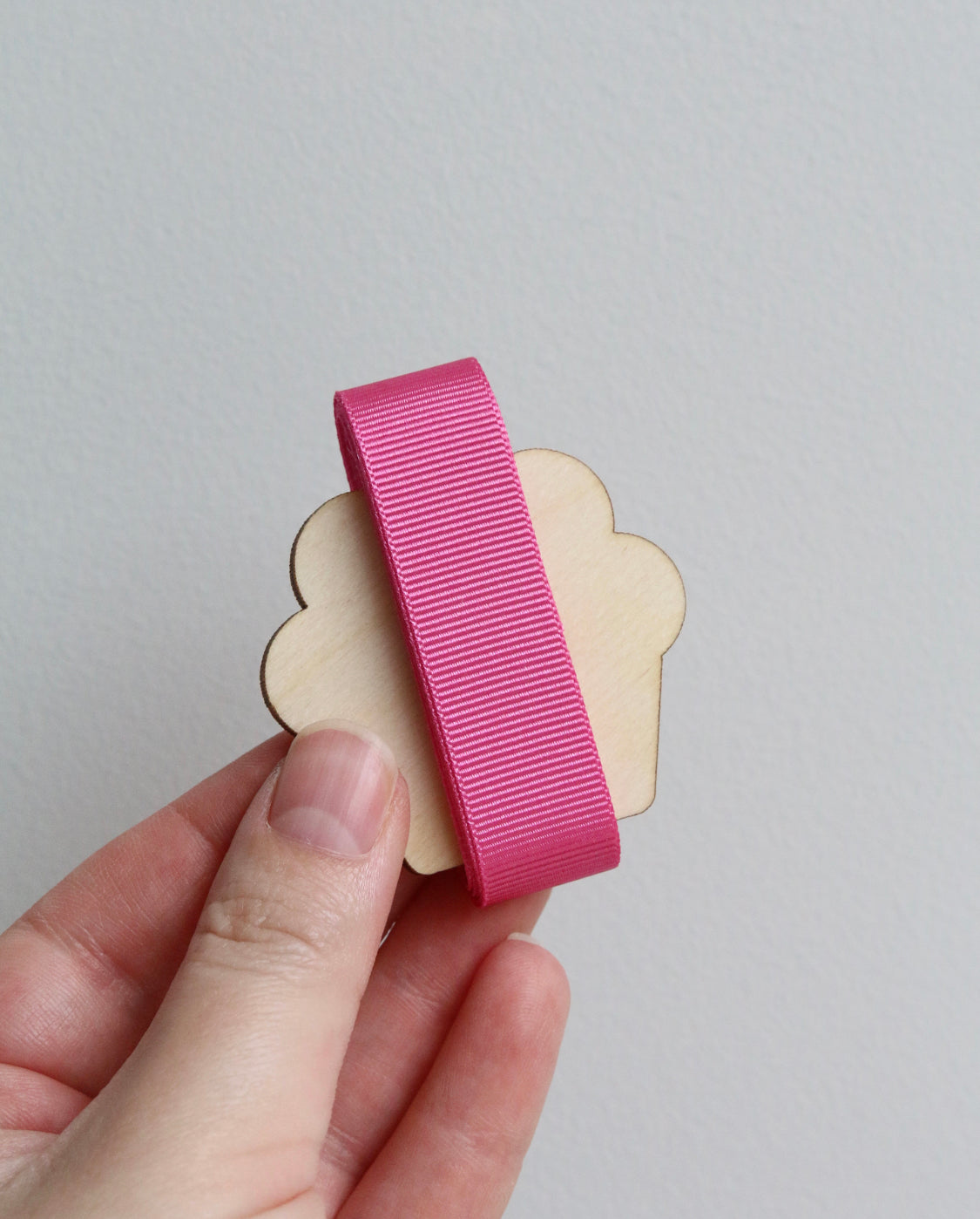 Bright pink grosgrain ribbon on wooden cutout cupcake