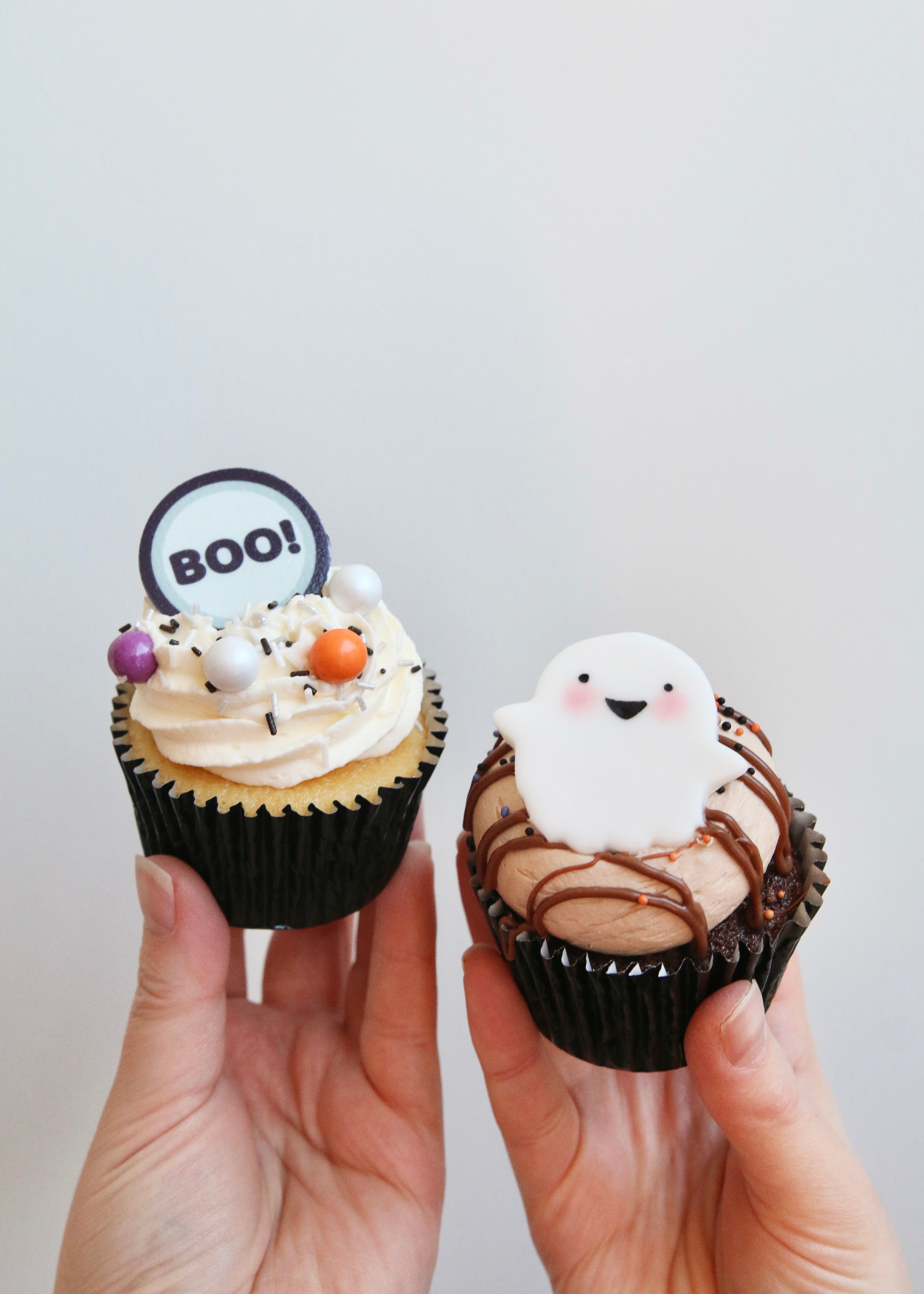 Holding Boo and Ghost Halloween Cupcakes
