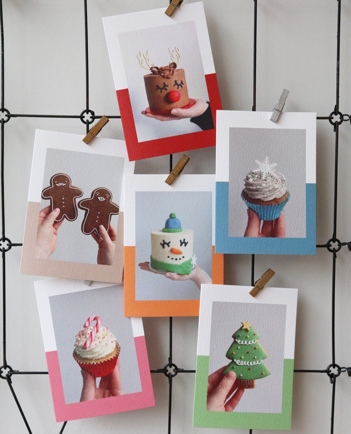 Selection of Christmas Cards with Photos of Cakes, Cupcakes and Biscuits Hanging on Wall