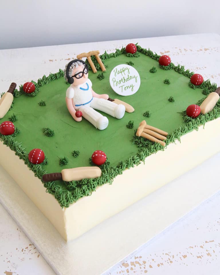 Rectangle Buttercream Cake with Green Grass Top, Cricket Player Figure and Cricket Decorations including balls, bats and wickets