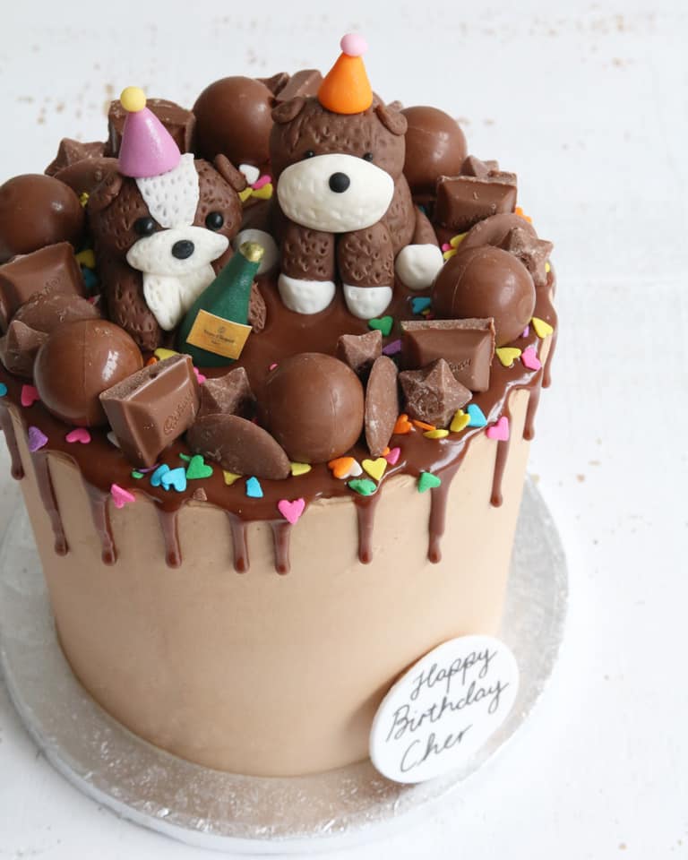 Chocolate drip cake wit dog figures in party hats