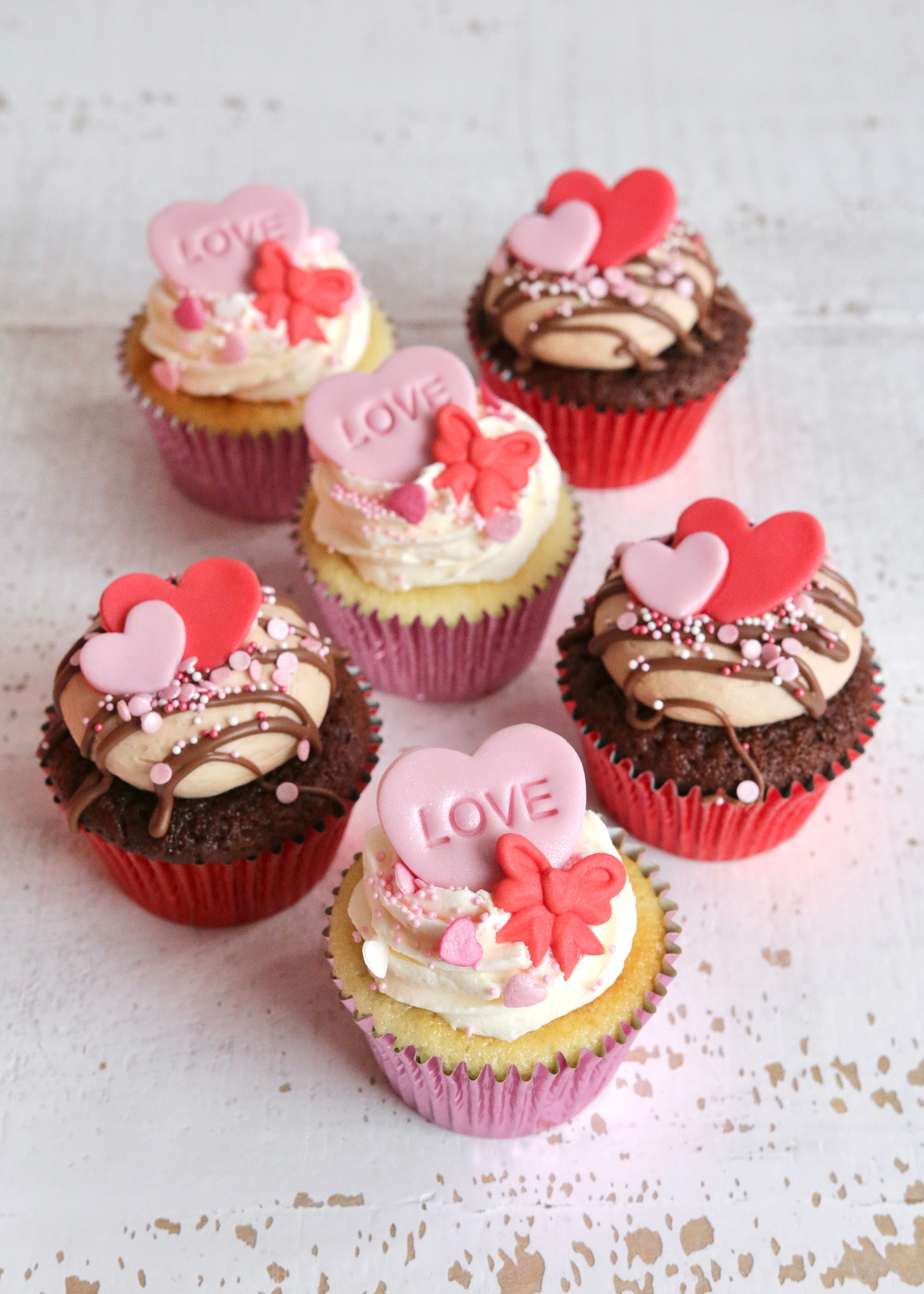 Valentine's Vanilla & Chocolate Cupcakes with Pink & Red Heart & Bow Decorations on a table