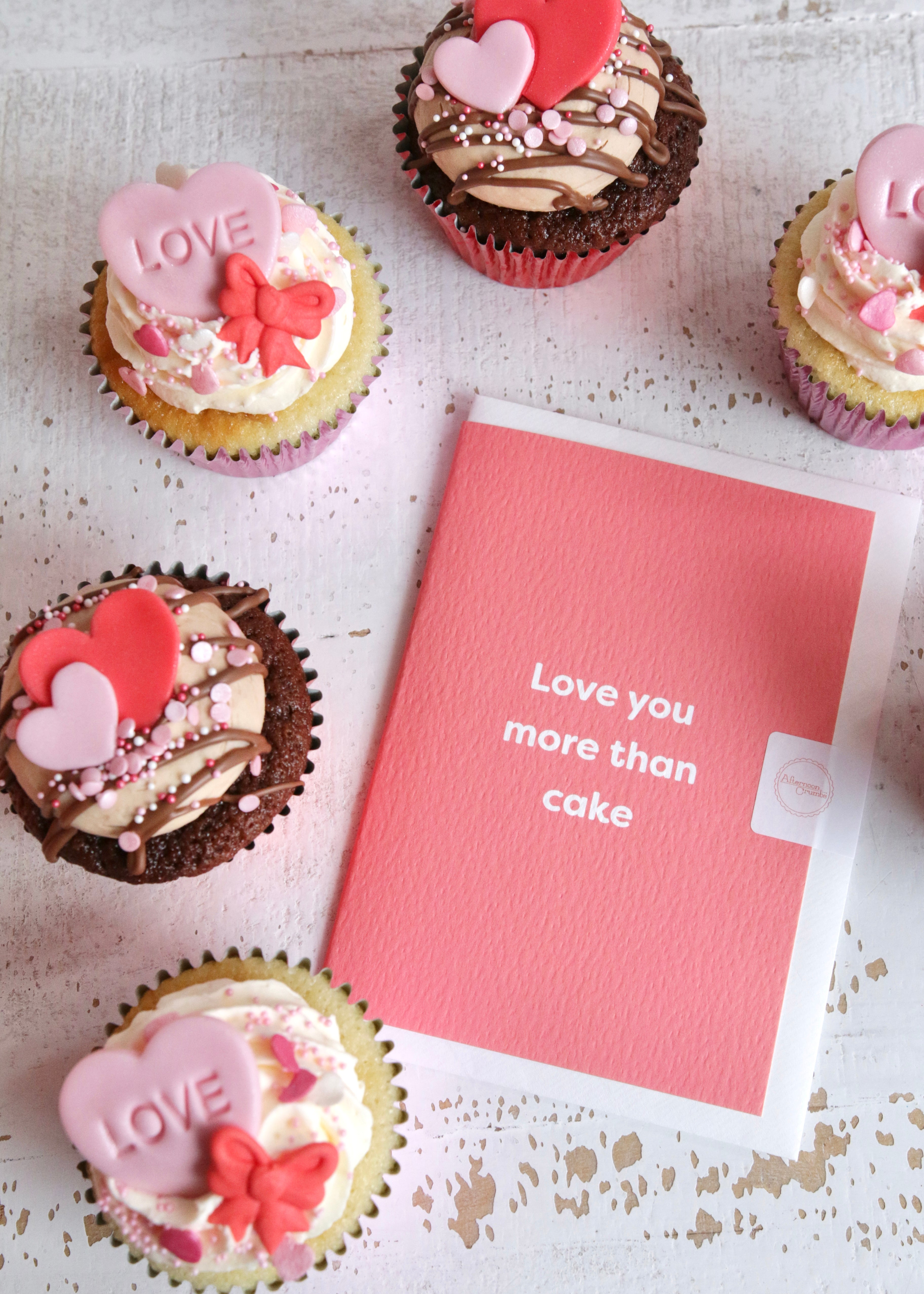Valentine's Vanilla & Chocolate Cupcakes with Pink & Red Heart & Bow Decorations with Valentine's Card - Pink with Text to Read Love You More Than Cake