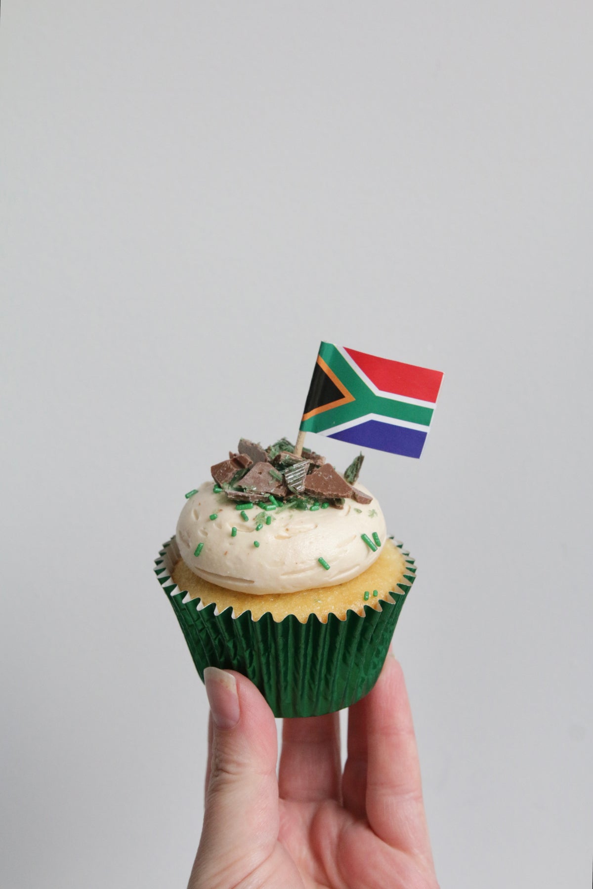 Holding a Single Peppermint Crisp Cupcake with South African Flag