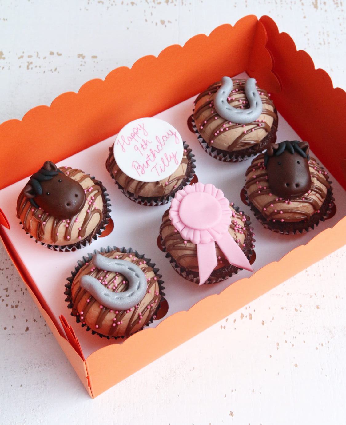 Box of Horse Themed Cupcakes with Horses, Horseshoes , a Pink Rosette and Birthday Message
