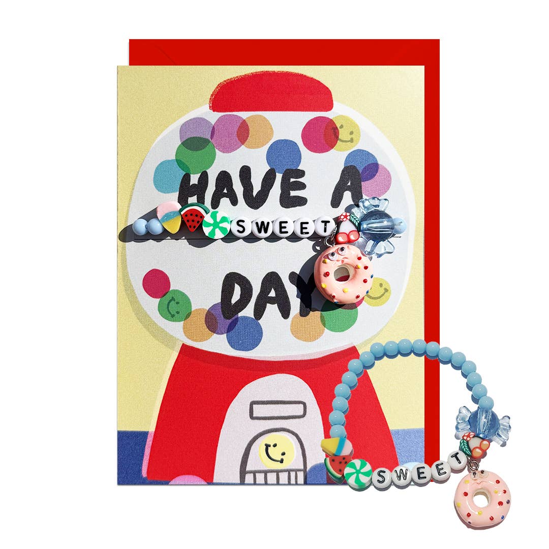 A colorful greeting card featuring a gumball machine illustration with the words 'HAVE A SWEET DAY' and a blue beaded bracelet with a donut charm, and beads spelling 'SWEET' shown on a white background