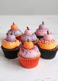 Halloween cupcakes topped with pastel pink, orange and purple buttercream and fondant pumpkins
