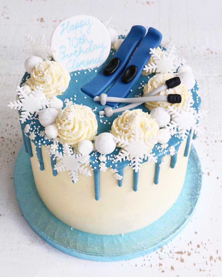 Skiing Themed Buttercream Birthday Cake with Blue Drip, Snowflakes and Fondant Skiis