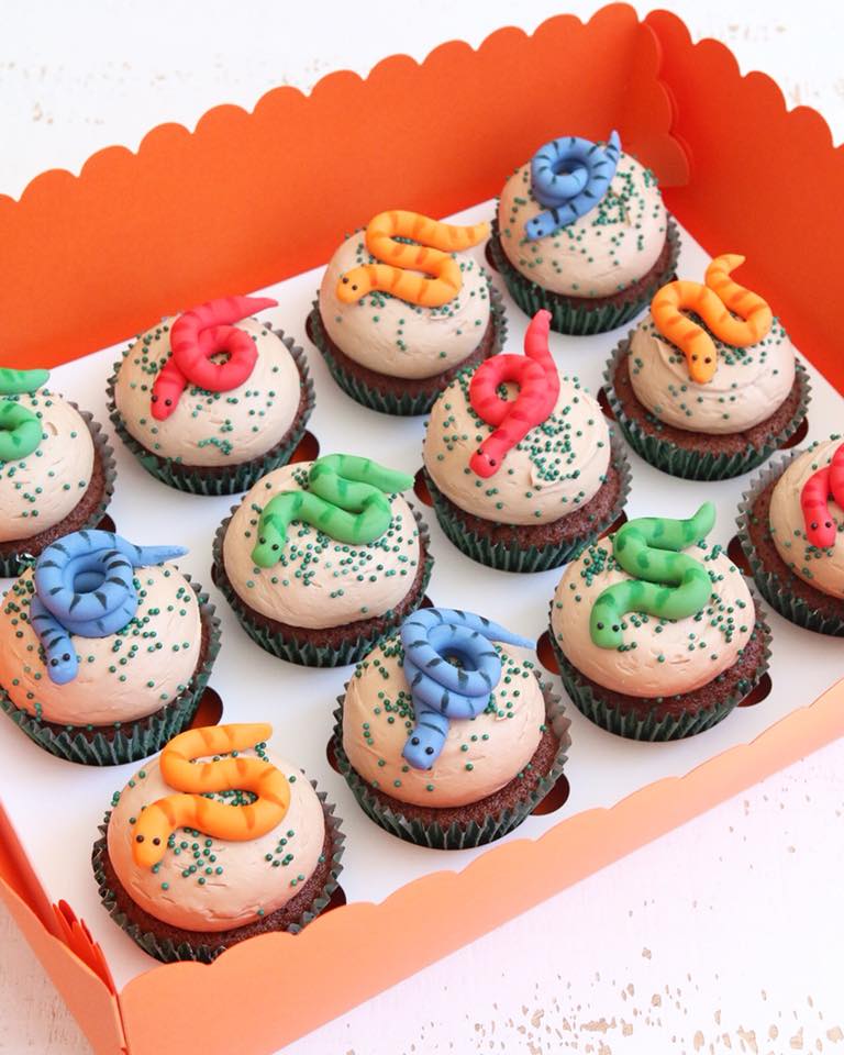 Cupcakes with brightly coloured snake decorations