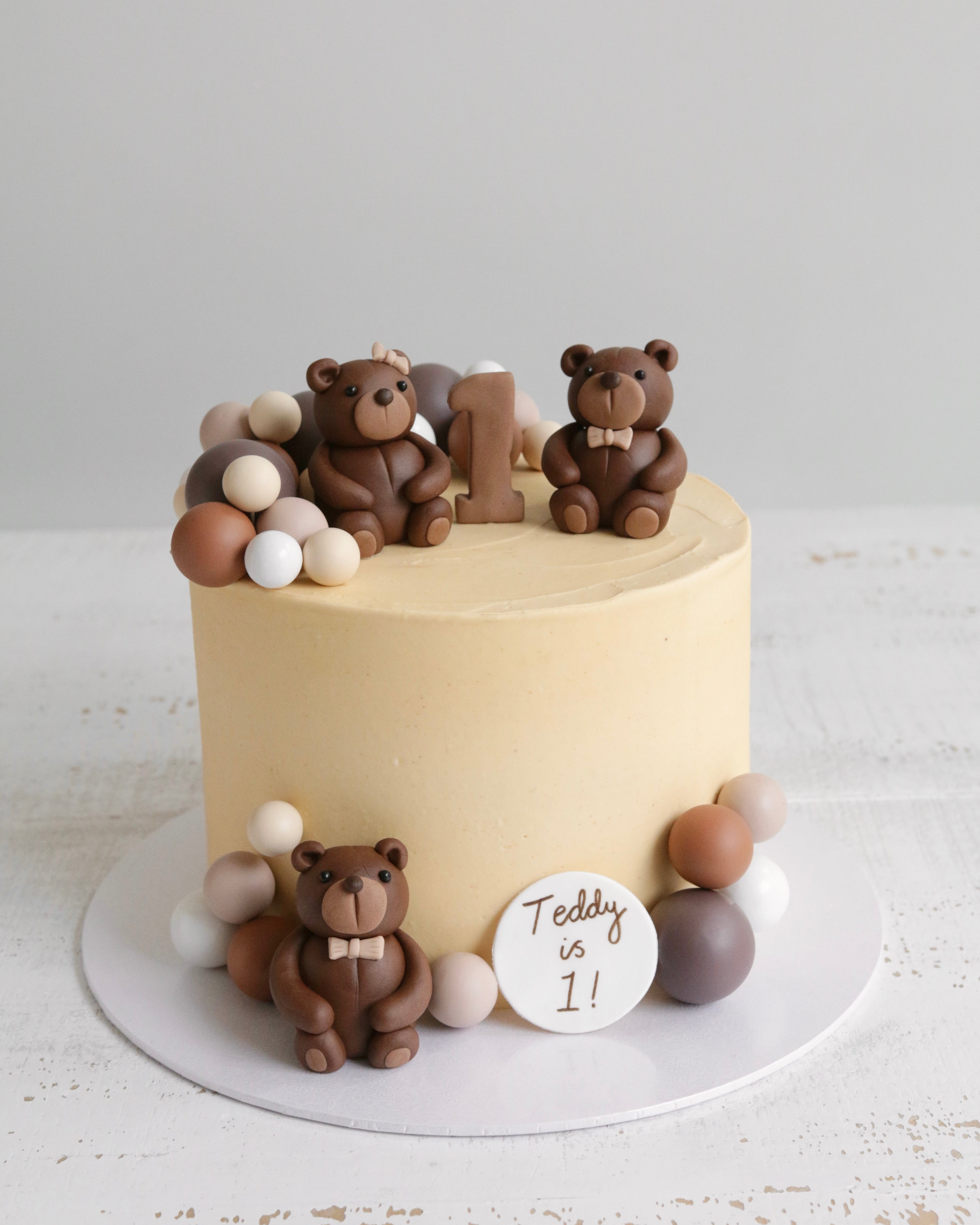 Teddy Bear 1st Birthday Cake with Three Brown Fondant Teddies and Brown and Cream Ball Decorations