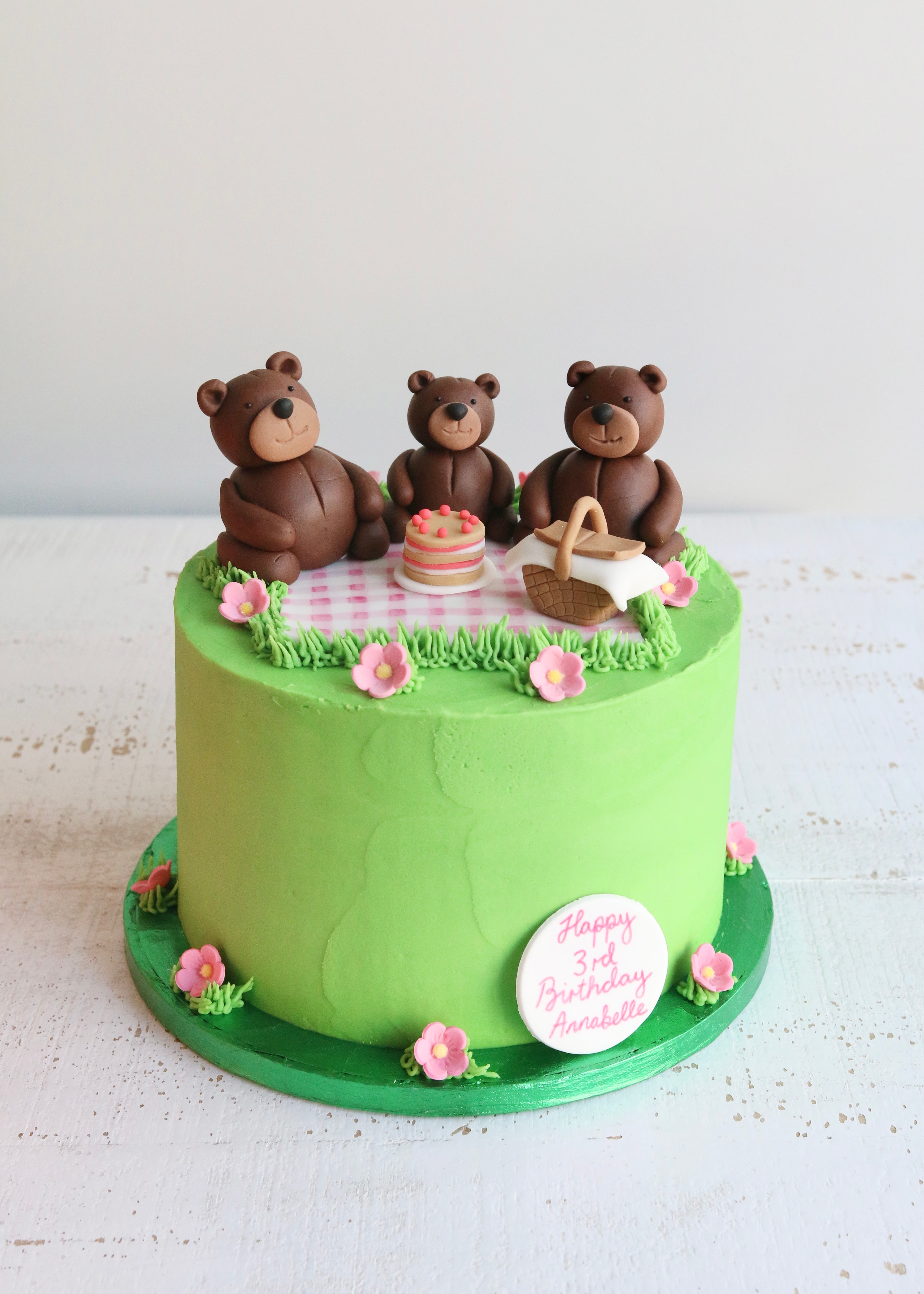 Green Cake Decorated with Three Teddies Having a Teddy Bear's Picnic