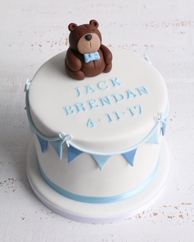 White Fondant Christening Cake with Blue Bunting, Name and Date and a Brown Teddy in a Blue Bow Tie