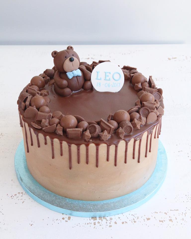 Chocolate Drip Cake Decorated with Chocolates, a Brown Teddy in a Blue Bow Tie and a plaque with a name and date