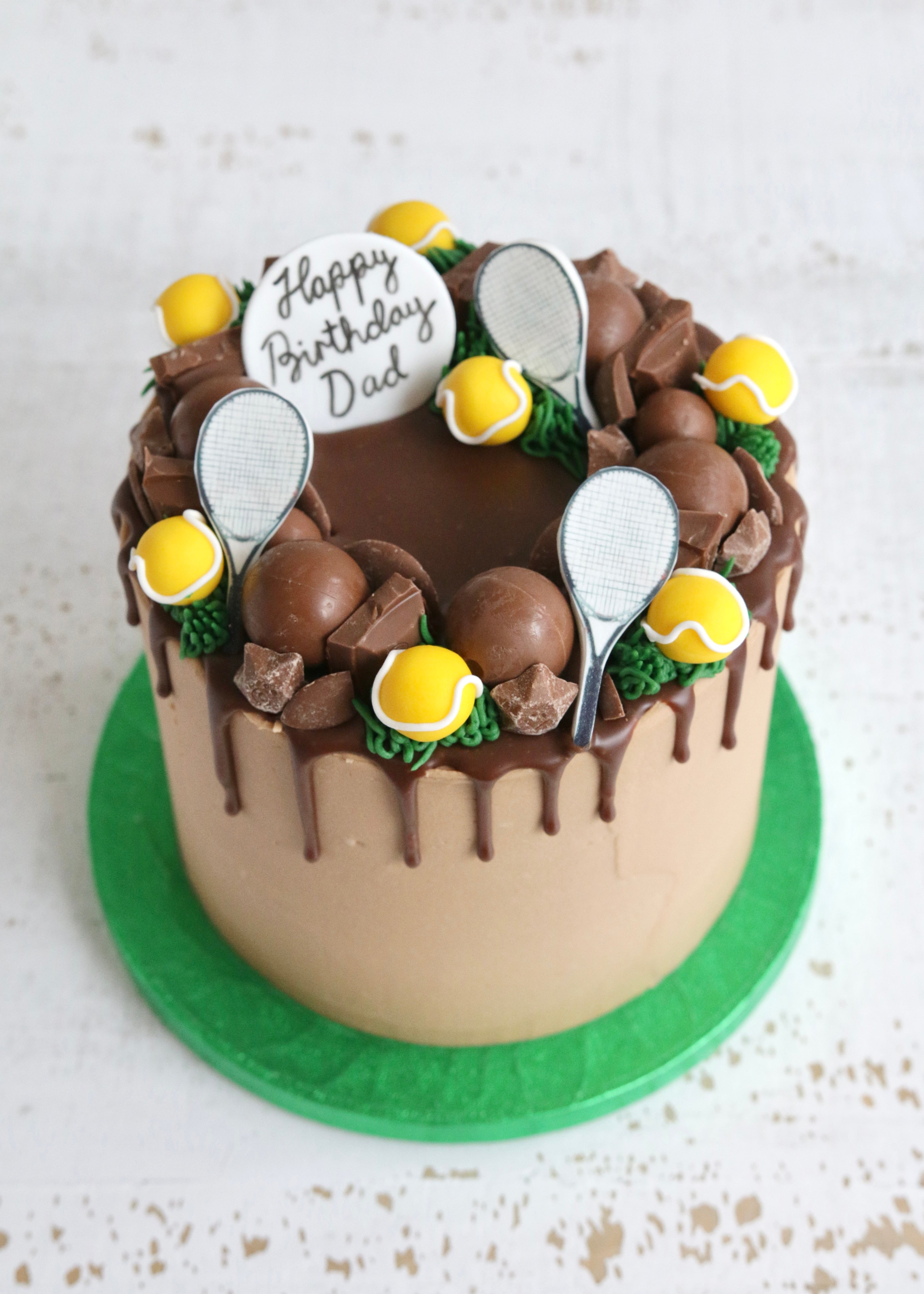 Chocolate Drip Cake with Tennis Balls and Tennis Racket Decorations