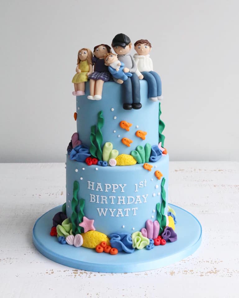 Two Tier First Birthday Cake with Under The Sea Decorations and Figures on Five Family Members on Top