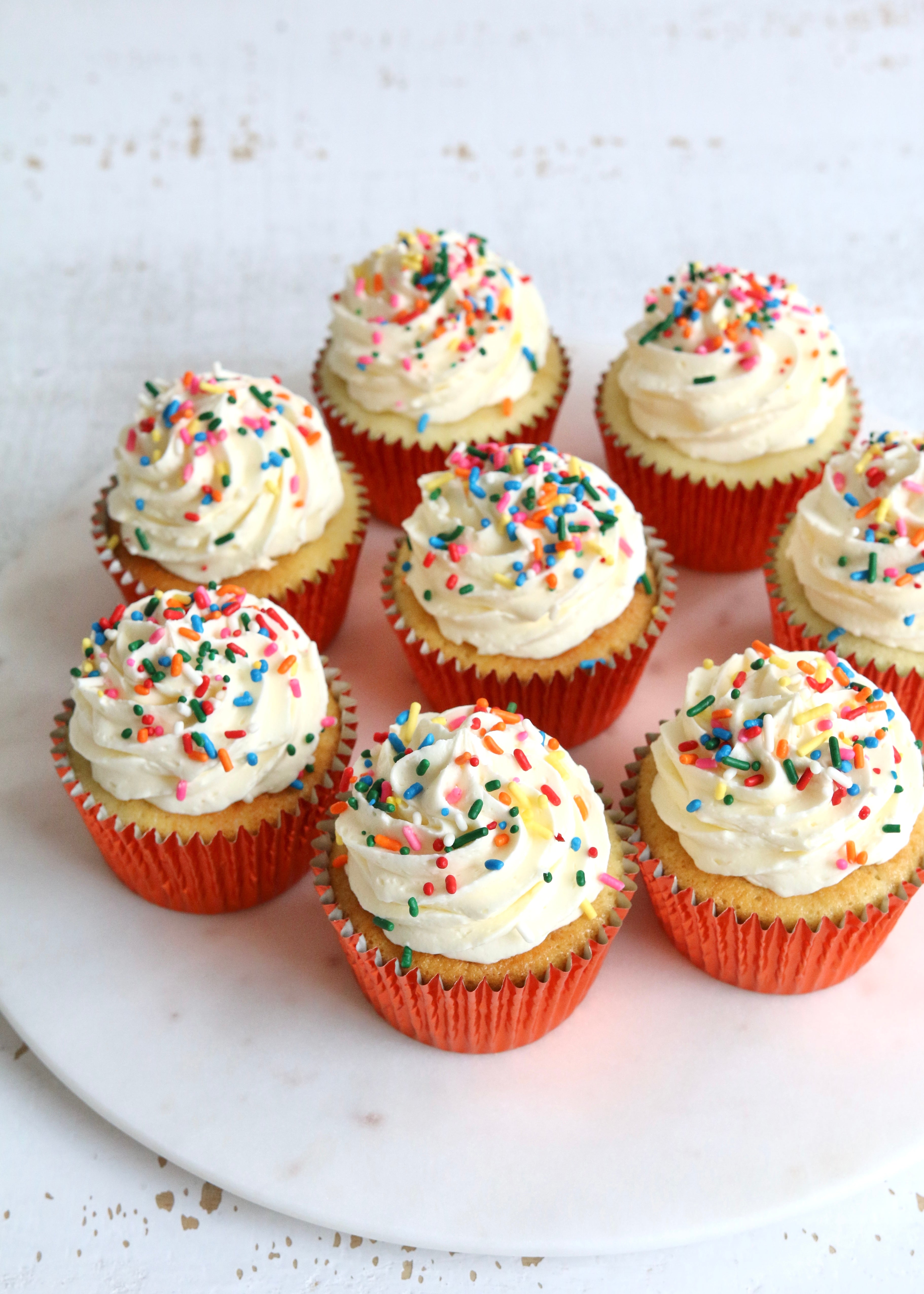 Vanilla Cupcakes with Rainbow Sprinkles in Orange Cases