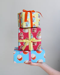 Stack of three presents wrapped with cake wrapping paper