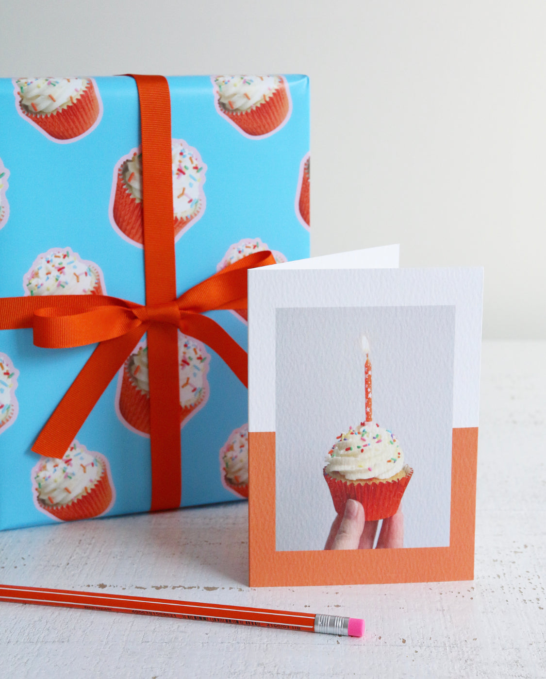 Orange Cupcake Birthday Wrapping Paper tied with Orange Ribbon with Orange Cupcake Card and Orange Pencil
